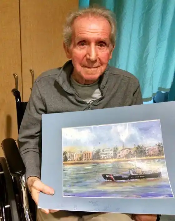 Tony Agresta continued to remember his time in the Coast Guard fondly. In this photo, he posed with a painting he completed of Coast Guard Cutter Rambler.