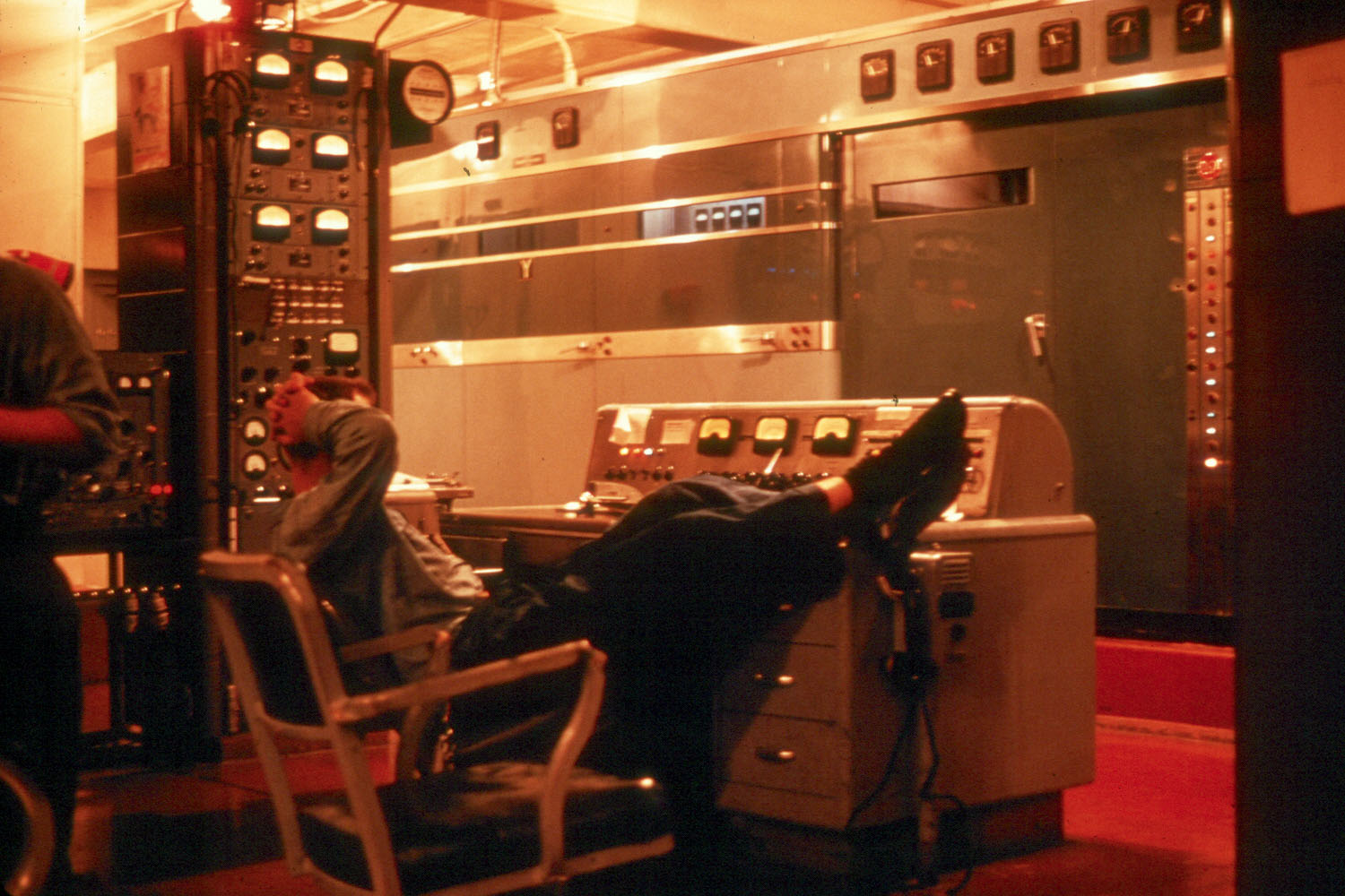 A Coast Guard Cutter Courier electronics technician stands, or perhaps sits, the watch at the controls of the massive 150,000-watt RCA transmitter. (The crew of the Coast Guard Cutter Courier, as collected by the Coast Guard Cutter  Courier/VOA Association)