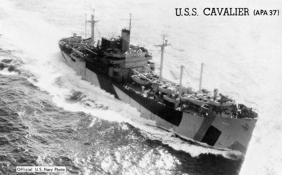 Aerial photo of Coast Guard-manned transport, USS Cavalier, in the Pacific under a full head of steam showing ship’s cranes and landing craft on deck. (U.S. Navy photo)